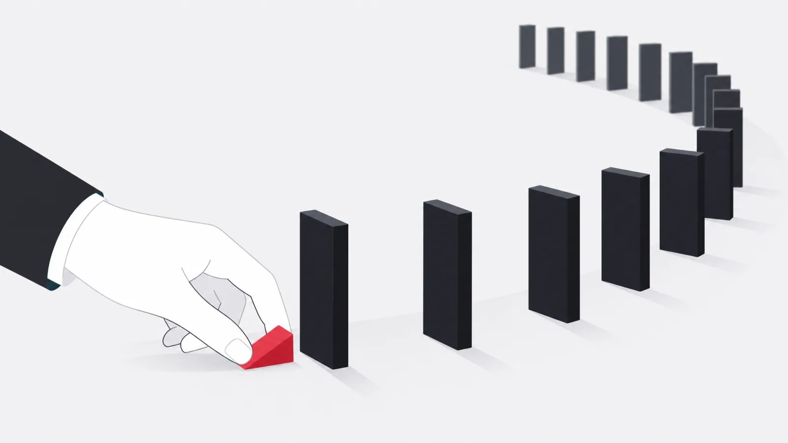 A hand placing a small red wedge that stops a run of dominoes from falling