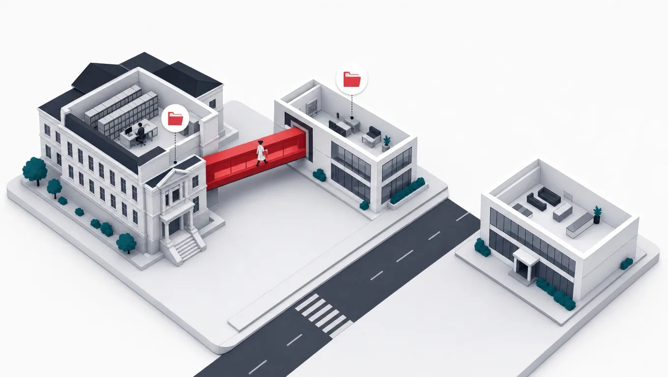 A modern app wing joined to an older records building by one bold red corridor, with a detached unused wing across the street